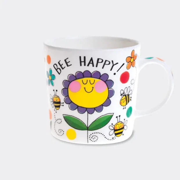 White mug covered in a big yellow and purple flower, then smaller flowers and bumble bees, with text saying Bee Happy.